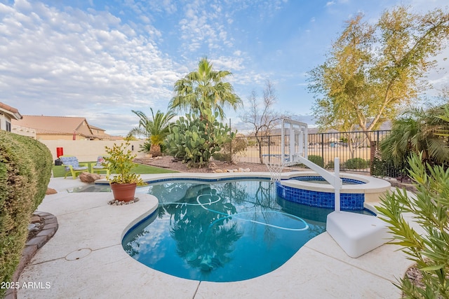 view of pool featuring a pool with connected hot tub, a patio area, and a fenced backyard