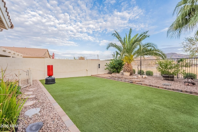 view of yard featuring a fenced backyard and a mountain view