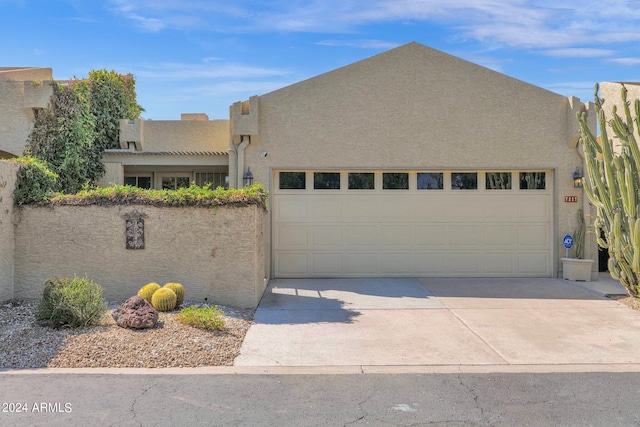 pueblo-style house featuring a garage