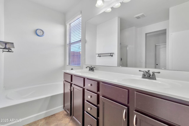 bathroom with tile patterned floors, vanity, and a bathing tub