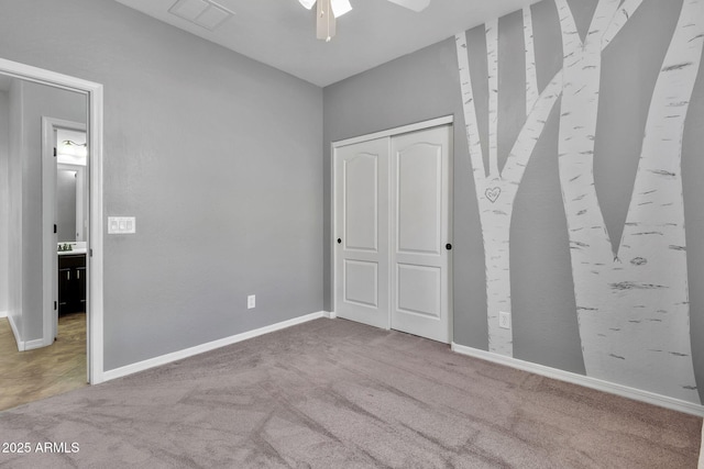 unfurnished bedroom with ceiling fan, a closet, and carpet