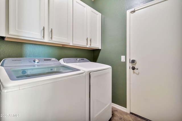 laundry area with separate washer and dryer and cabinets