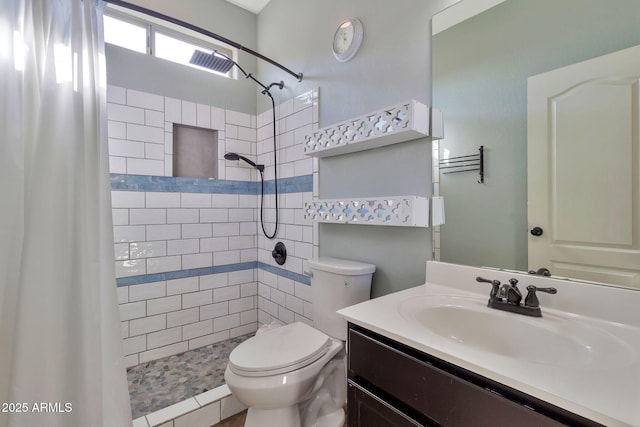 bathroom with toilet, vanity, and tiled shower