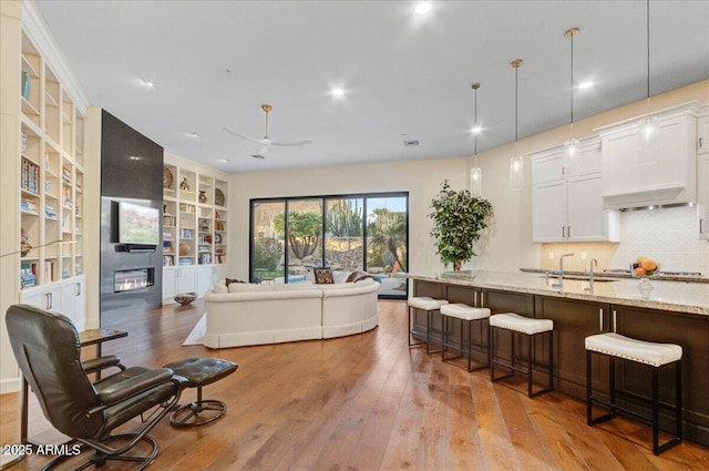 living room with hardwood / wood-style flooring, sink, and a fireplace