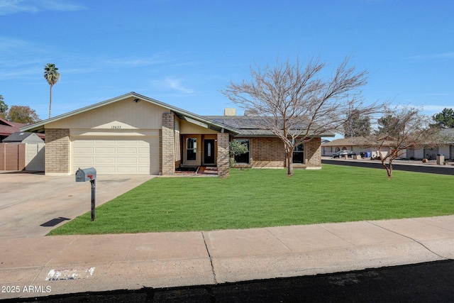 mid-century home with a garage, a front yard, concrete driveway, and brick siding