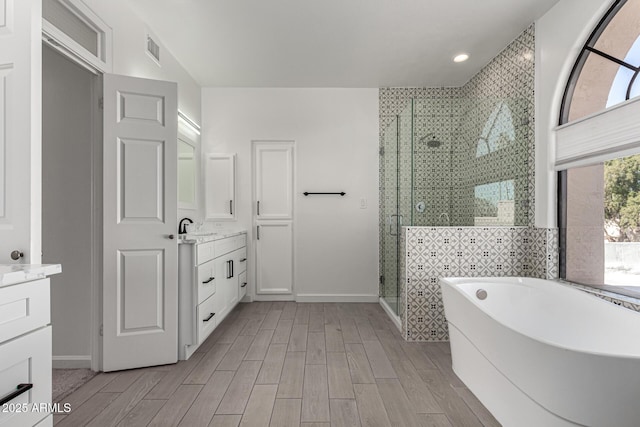 bathroom featuring vanity and plus walk in shower