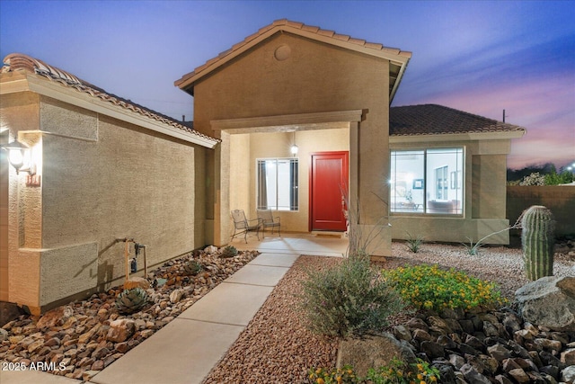 3604 E Derringer Way, Gilbert, AZ 85297 - exterior entry at dusk with stucco siding and a tile roof