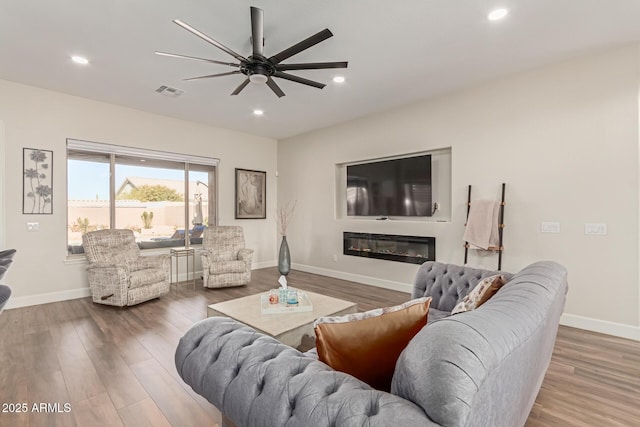 living room featuring hardwood / wood-style floors and ceiling fan