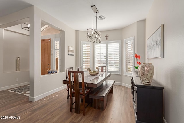 dining area featuring an inviting chandelier and dark hardwood / wood-style flooring