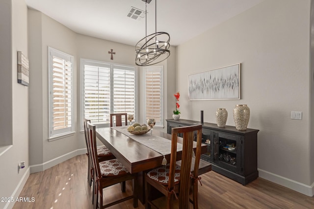 dining room with hardwood / wood-style flooring and a notable chandelier