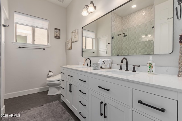 bathroom featuring vanity, a shower with door, and toilet