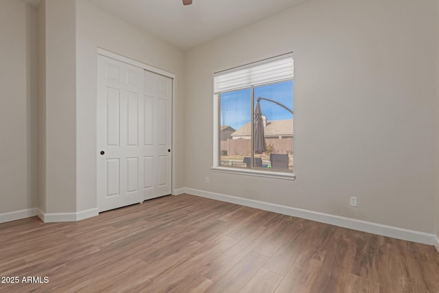 unfurnished bedroom with wood-type flooring, a closet, and ceiling fan