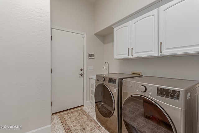 laundry room featuring light tile patterned flooring, cabinets, and washing machine and clothes dryer