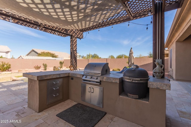 view of patio featuring area for grilling, a pergola, and an outdoor kitchen