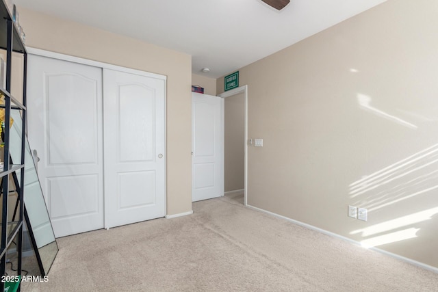 unfurnished bedroom with a closet and light carpet