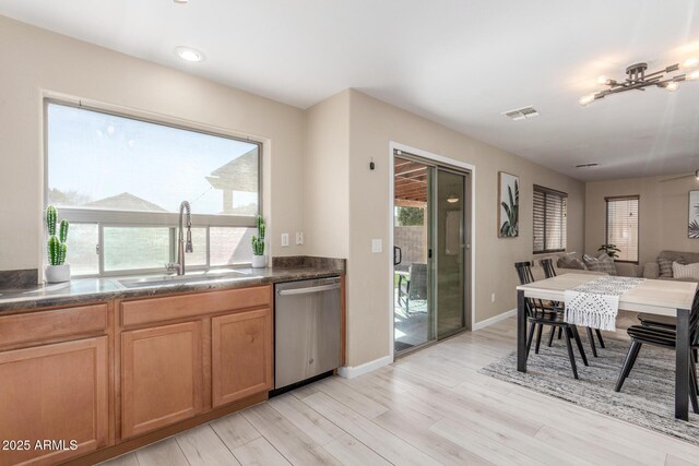 kitchen with light hardwood / wood-style flooring, stainless steel dishwasher, plenty of natural light, and sink