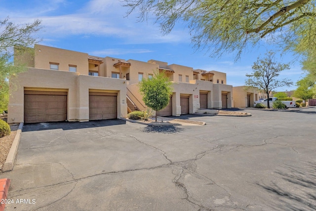 pueblo-style house with a balcony and a garage