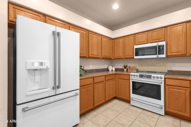 kitchen with light tile patterned flooring and white appliances