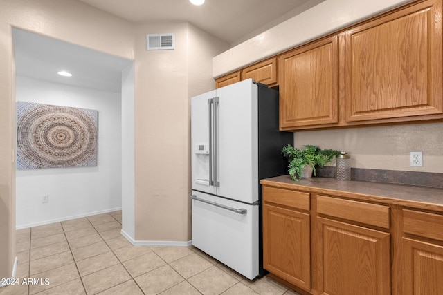 kitchen featuring white refrigerator with ice dispenser and light tile patterned flooring