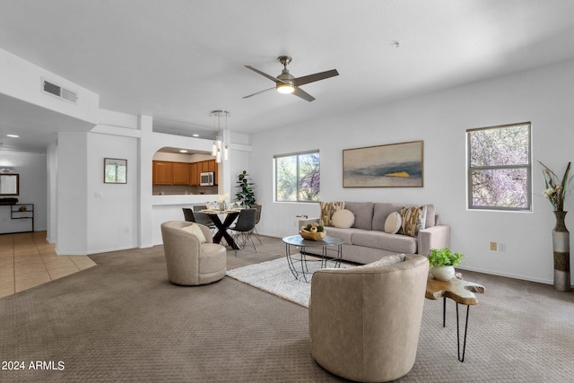 carpeted living room with ceiling fan