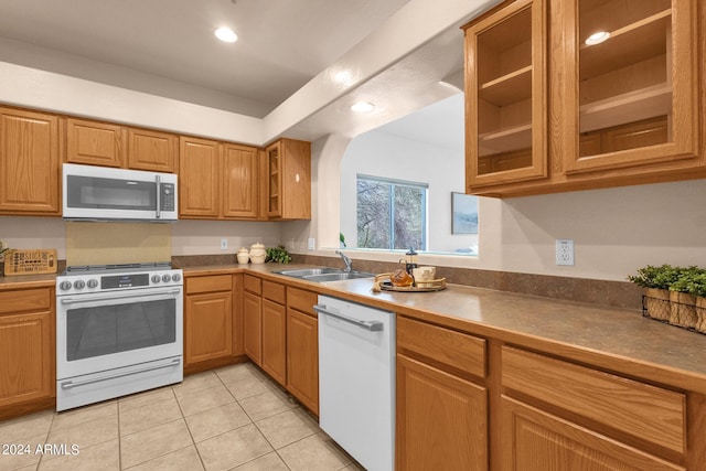 kitchen with light tile patterned floors, sink, and white appliances