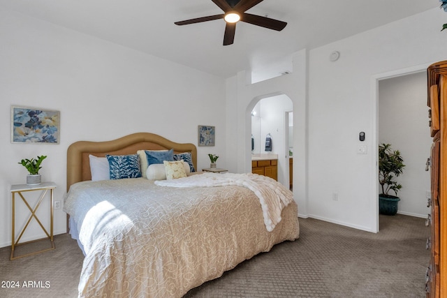 carpeted bedroom with ceiling fan and ensuite bath