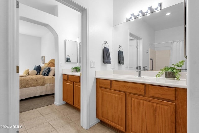 bathroom with tile patterned flooring, walk in shower, and vanity