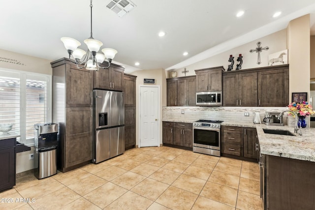 kitchen featuring stainless steel appliances, dark brown cabinets, sink, and decorative light fixtures