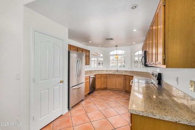 kitchen featuring pendant lighting, sink, light tile patterned floors, stainless steel appliances, and light stone counters