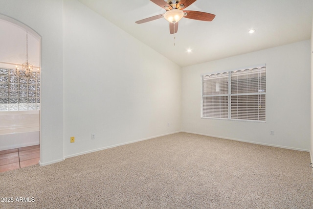 spare room featuring ceiling fan with notable chandelier, lofted ceiling, and carpet floors