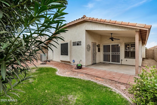 rear view of property featuring ceiling fan, a yard, a patio area, and central air condition unit