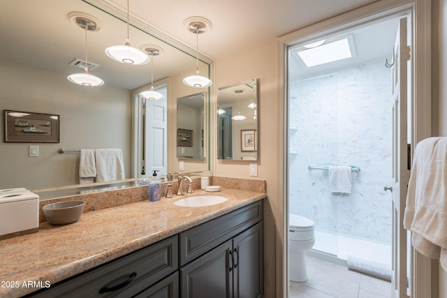 2413 E Rancho Dr, Phoenix, AZ 85016 - full bath with toilet, vanity, a shower stall, tile patterned flooring, and a skylight