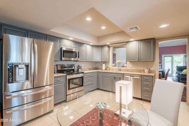 2413 E Rancho Dr, Phoenix, AZ 85016 - kitchen with stainless steel appliances, gray cabinets, light tile patterned flooring, a sink, and recessed lighting