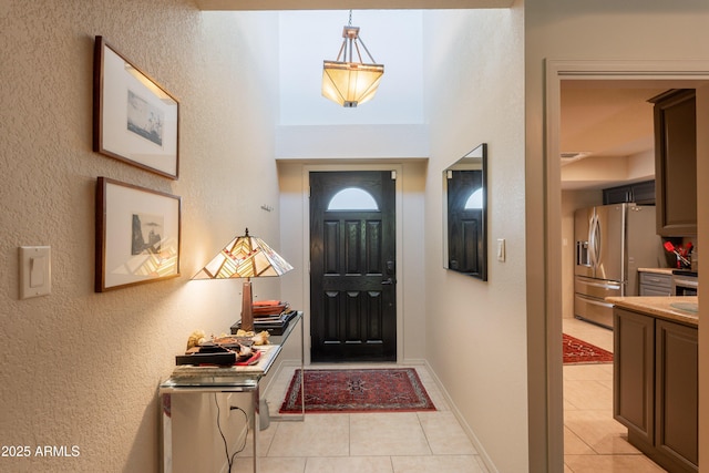 2413 E Rancho Dr, Phoenix, AZ 85016 - foyer with light tile patterned floors, a textured wall, and baseboards