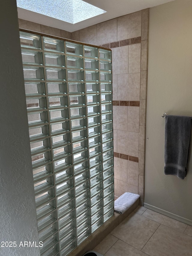 2413 E Rancho Dr, Phoenix, AZ 85016 - bathroom featuring tile patterned flooring, baseboards, a skylight, and tiled shower