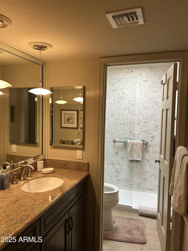 2413 E Rancho Dr, Phoenix, AZ 85016 - bathroom with vanity, toilet, a stall shower, tile patterned flooring, and a textured ceiling