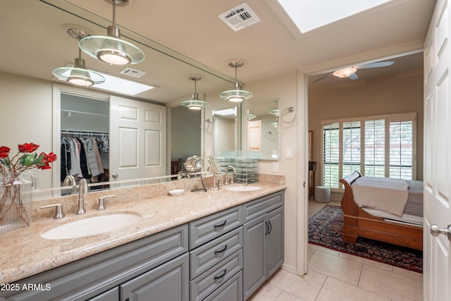 2413 E Rancho Dr, Phoenix, AZ 85016 - full bath featuring double vanity, tile patterned floors, ensuite bath, a skylight, and a spacious closet