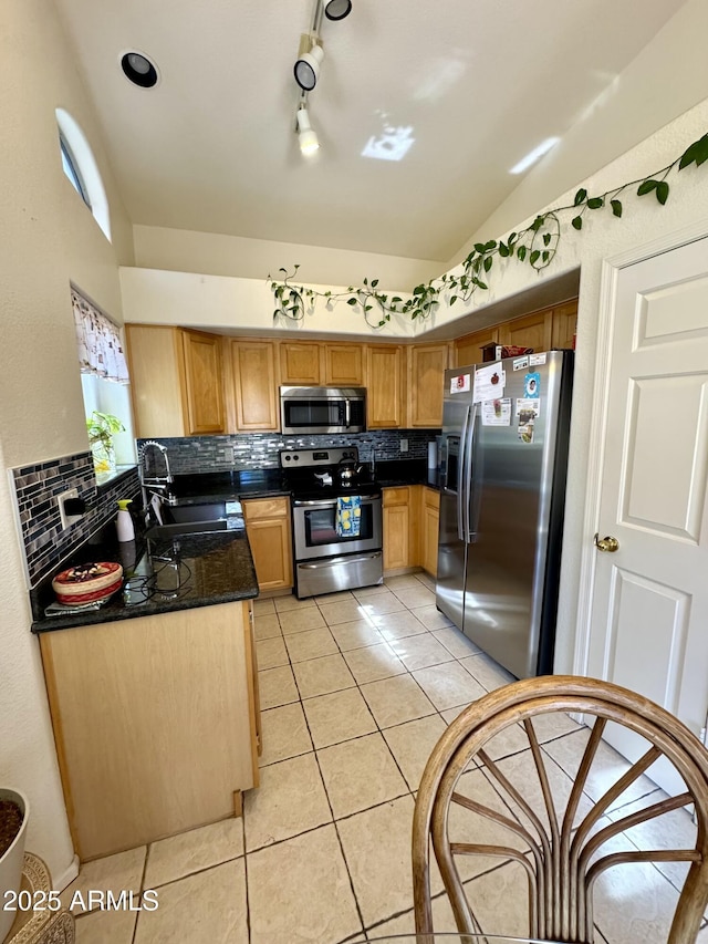 kitchen featuring stainless steel appliances, vaulted ceiling, a sink, and tasteful backsplash