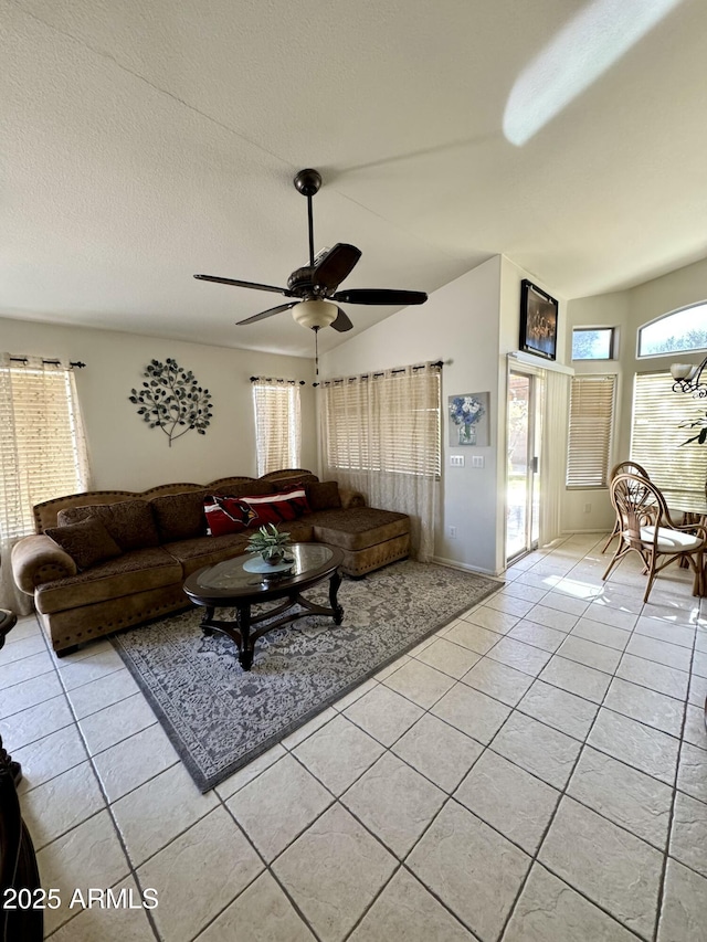 living room featuring ceiling fan, vaulted ceiling, a textured ceiling, and light tile patterned floors