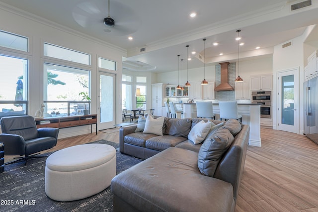 living room featuring ornamental molding, ceiling fan, and light hardwood / wood-style floors