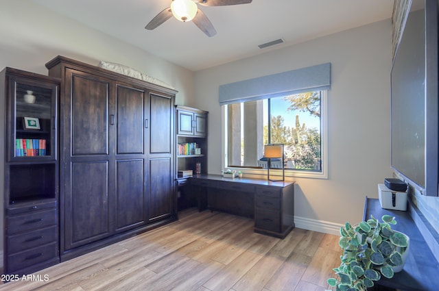 unfurnished office with ceiling fan and light wood-type flooring