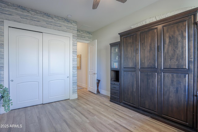 unfurnished bedroom featuring a closet, ceiling fan, and light hardwood / wood-style flooring