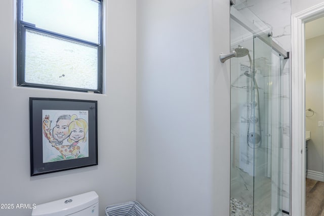 bathroom featuring an enclosed shower, hardwood / wood-style flooring, and toilet