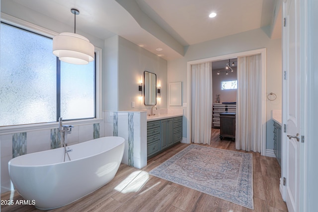 bathroom with vanity, tile walls, hardwood / wood-style flooring, and a bathing tub