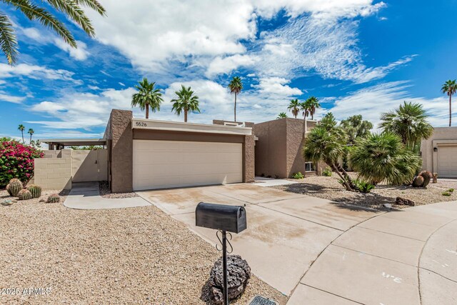 5526 N 77th Way, Scottsdale, AZ 85250 - view of front of home with driveway, stucco siding, a garage, and a gate