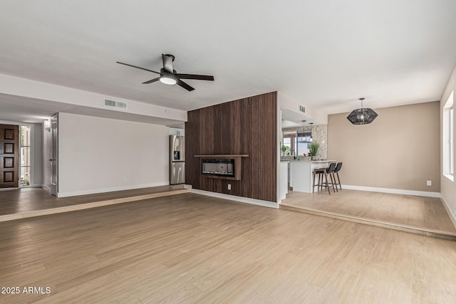 5526 N 77th Way, Scottsdale, AZ 85250 - unfurnished living room with ceiling fan, baseboards, and wood finished floors