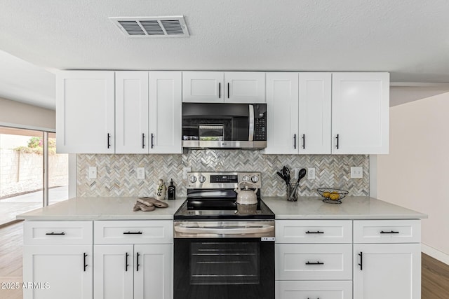5526 N 77th Way, Scottsdale, AZ 85250 - kitchen with stainless steel appliances, tasteful backsplash, light countertops, white cabinetry, and wood finished floors