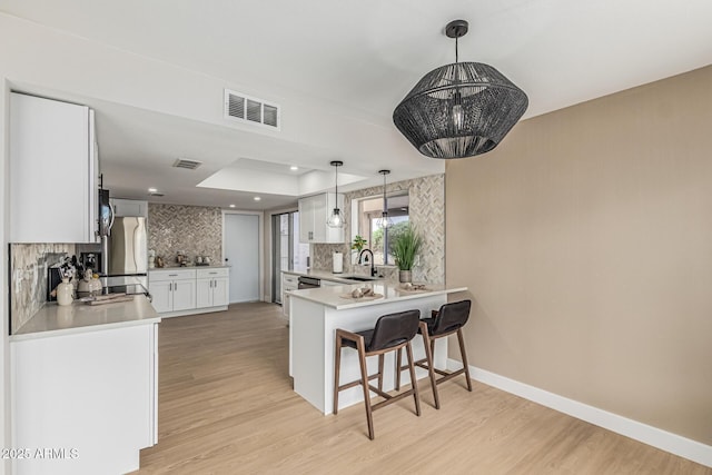 5526 N 77th Way, Scottsdale, AZ 85250 - kitchen with tasteful backsplash, a sink, a kitchen bar, light wood finished floors, and recessed lighting