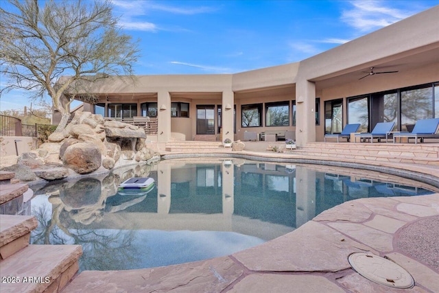 view of swimming pool with ceiling fan and a patio area