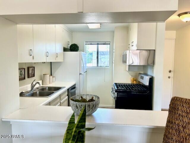 kitchen with range hood, a sink, white cabinetry, gas range, and light countertops